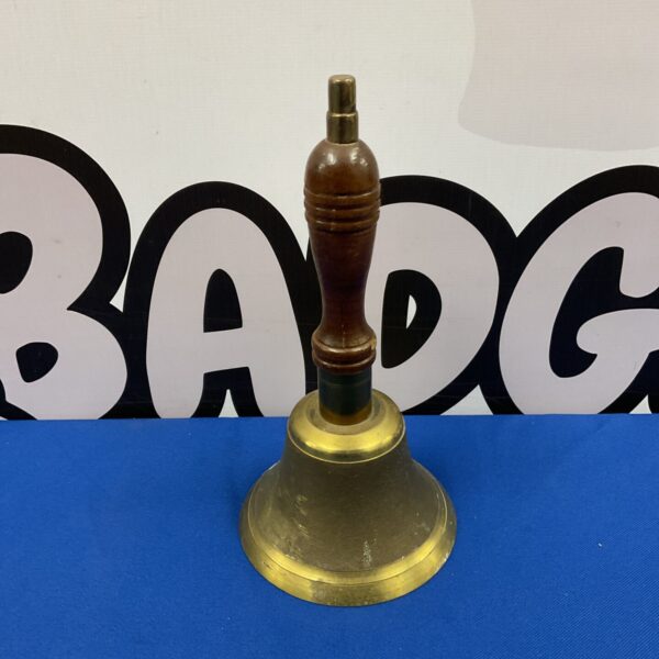 Vintage brass hand bell with wooden handle, classic design.