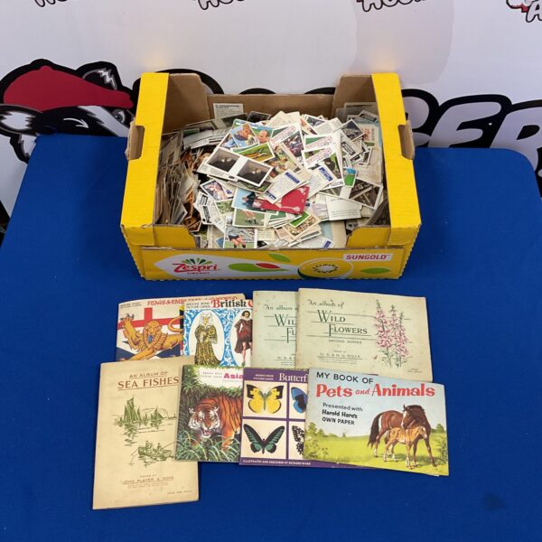 Loose vintage cigarette cards in a cardboard box, collectible ephemera.