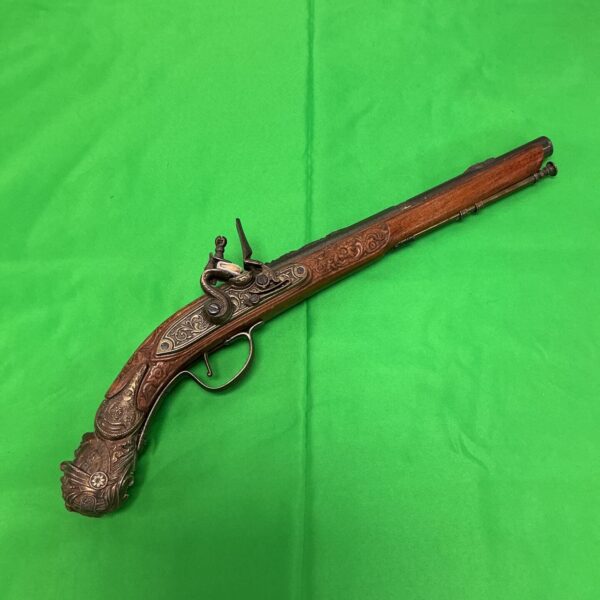 Ornate vintage flintlock pistol, antique firearm collectible.