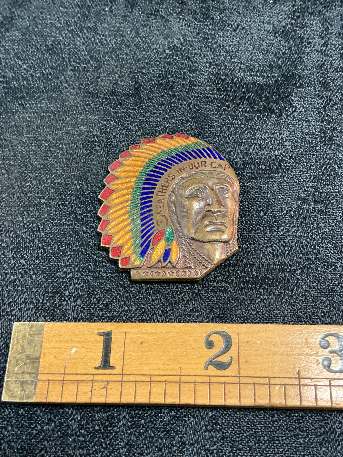 878 Vintage enamel copper Indian chief head inscribed “feathers in our cap” badge