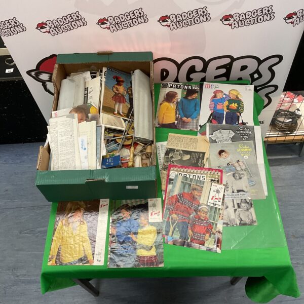 Vintage knitting patterns and needles in a box, retro craft supplies.