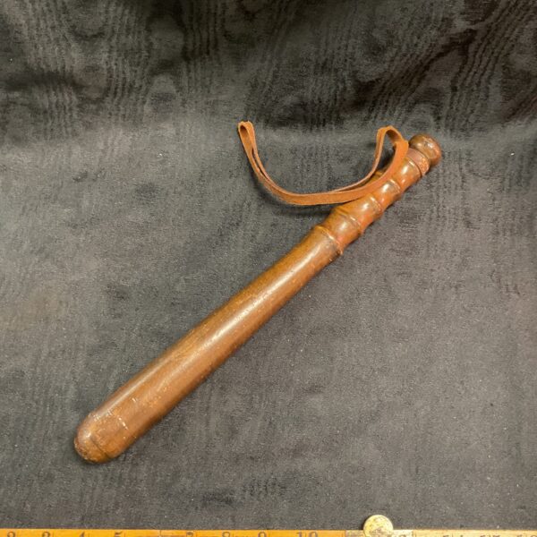 Vintage wooden police truncheon with leather wrist strap for collectors.