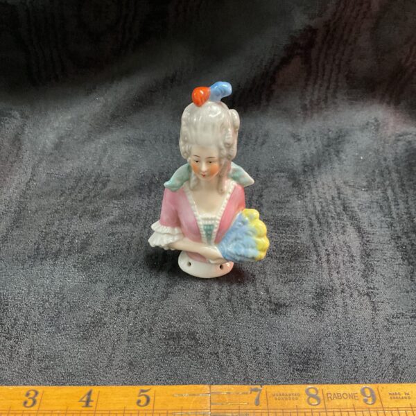Vintage porcelain pincushion top with a lady figurine.