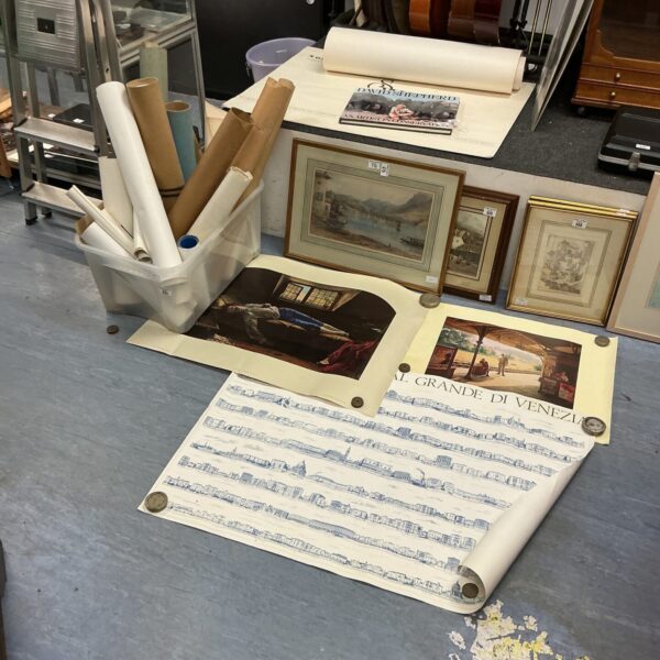 Rolled vintage posters in a large lot, collectible wall art.