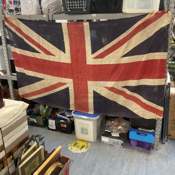 Large vintage Union Jack flag displayed indoors.
