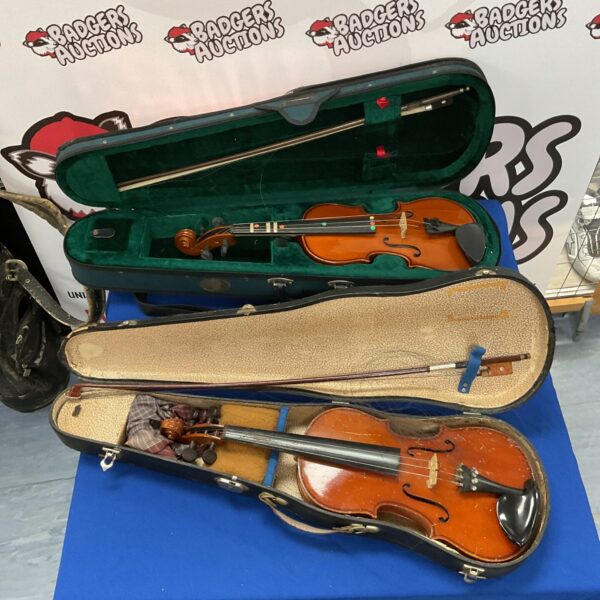 Two vintage violins in cases for restoration.