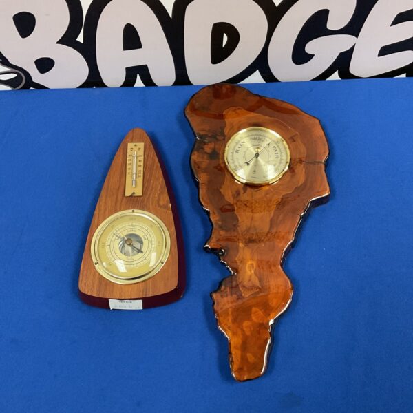 Pair of vintage wooden wall barometers with circular dials.