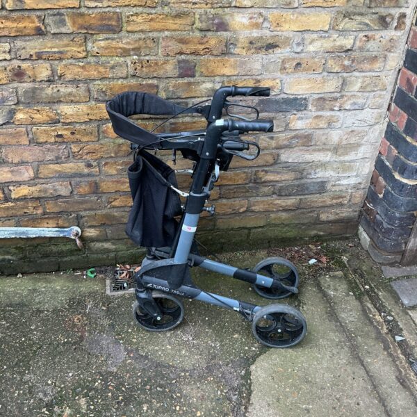 Front view of a used walking aid trolley with a seat.