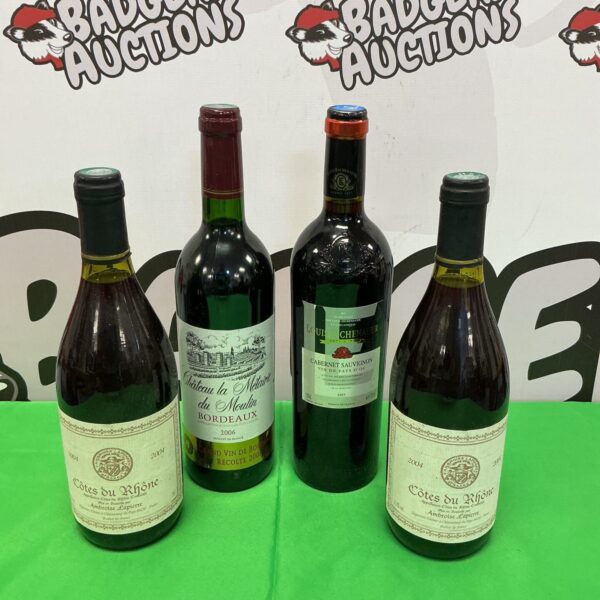 Four bottles of French wine including Côtes du Rhône and Bordeaux.