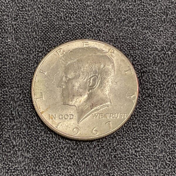 1967 Kennedy half dollar coin with visible details.