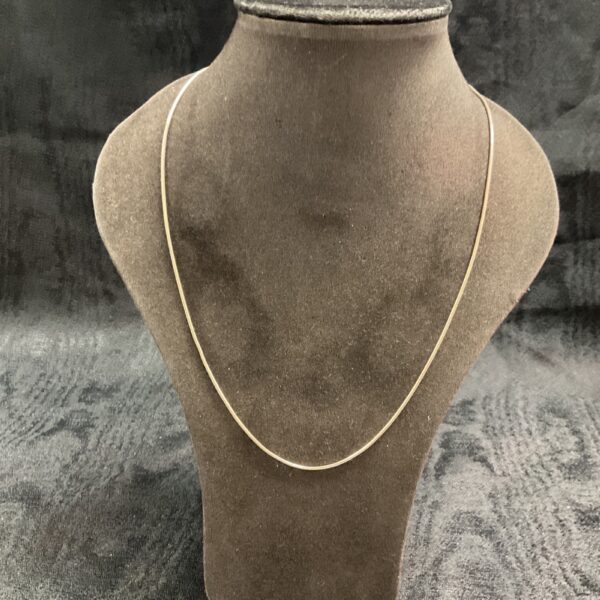 Close-up of a 925 silver snake chain necklace on a display stand.