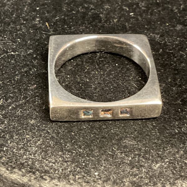 Close-up of a 925 silver square ring with cut-outs.