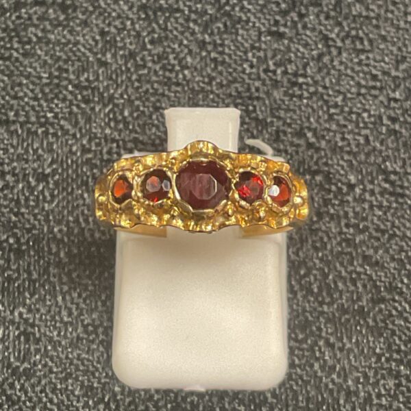 Close-up of a 9ct gold garnet ring with five stones.