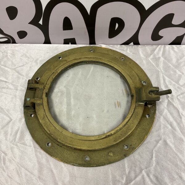 Antique brass ships porthole window with weathered patina.