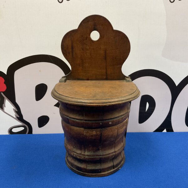 Antique oak salt pot mounted on a wall.