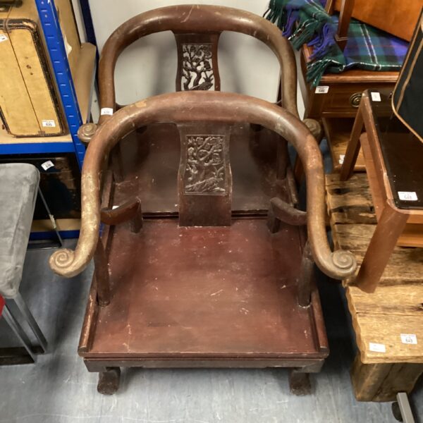 Intricately carved antique oriental armchair with floral details.