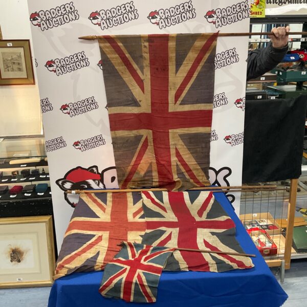 Lot of four antique Union Jack flags displayed indoors.