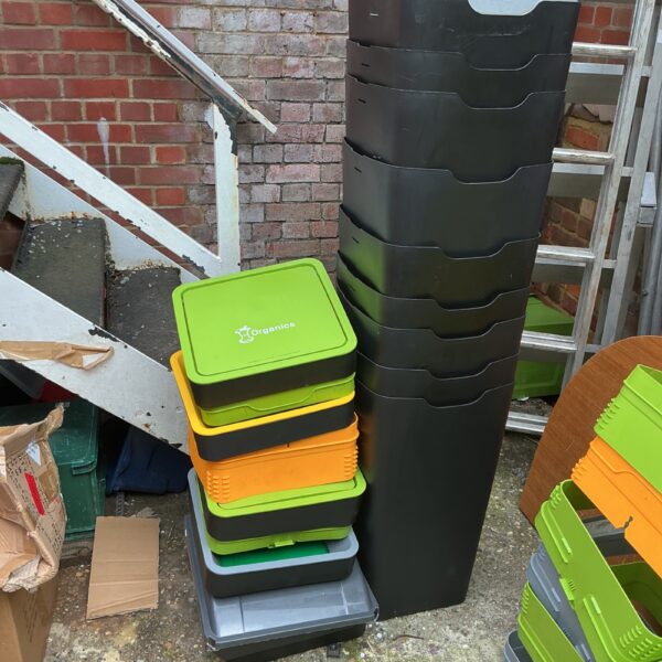 Stack of colourful plastic recycling bins for garden or household use.