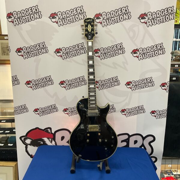Black Epiphone Les Paul Custom electric guitar needing strings.