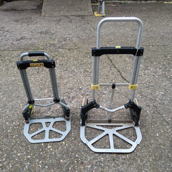 Pair of folding sack barrows for moving goods.