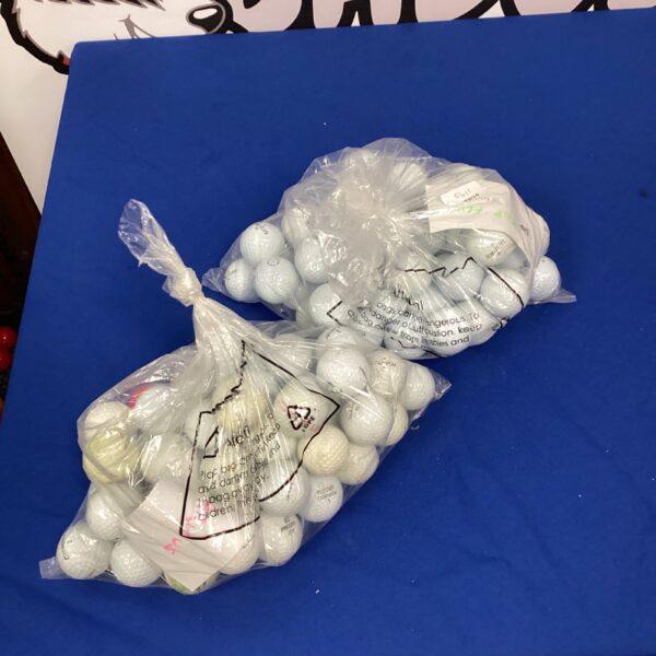 Mixed lot of used golf balls for practice and play.