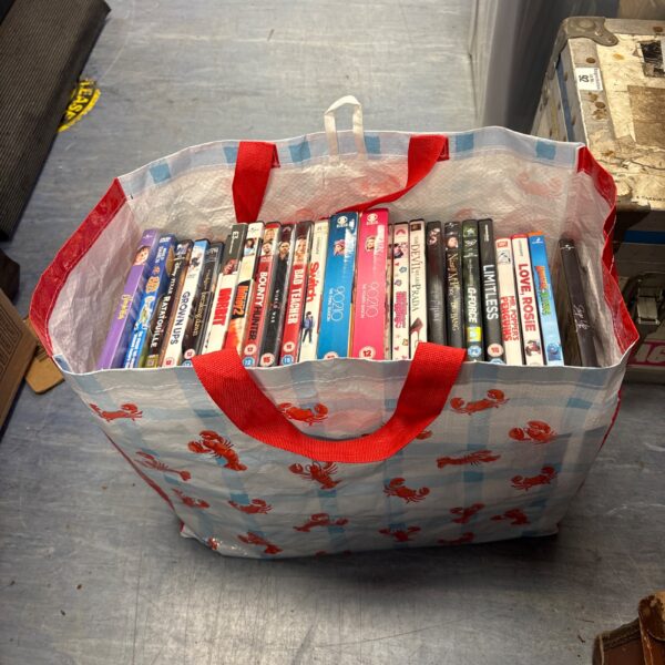 Blue bag filled with a large mixed DVD lot for home entertainment.