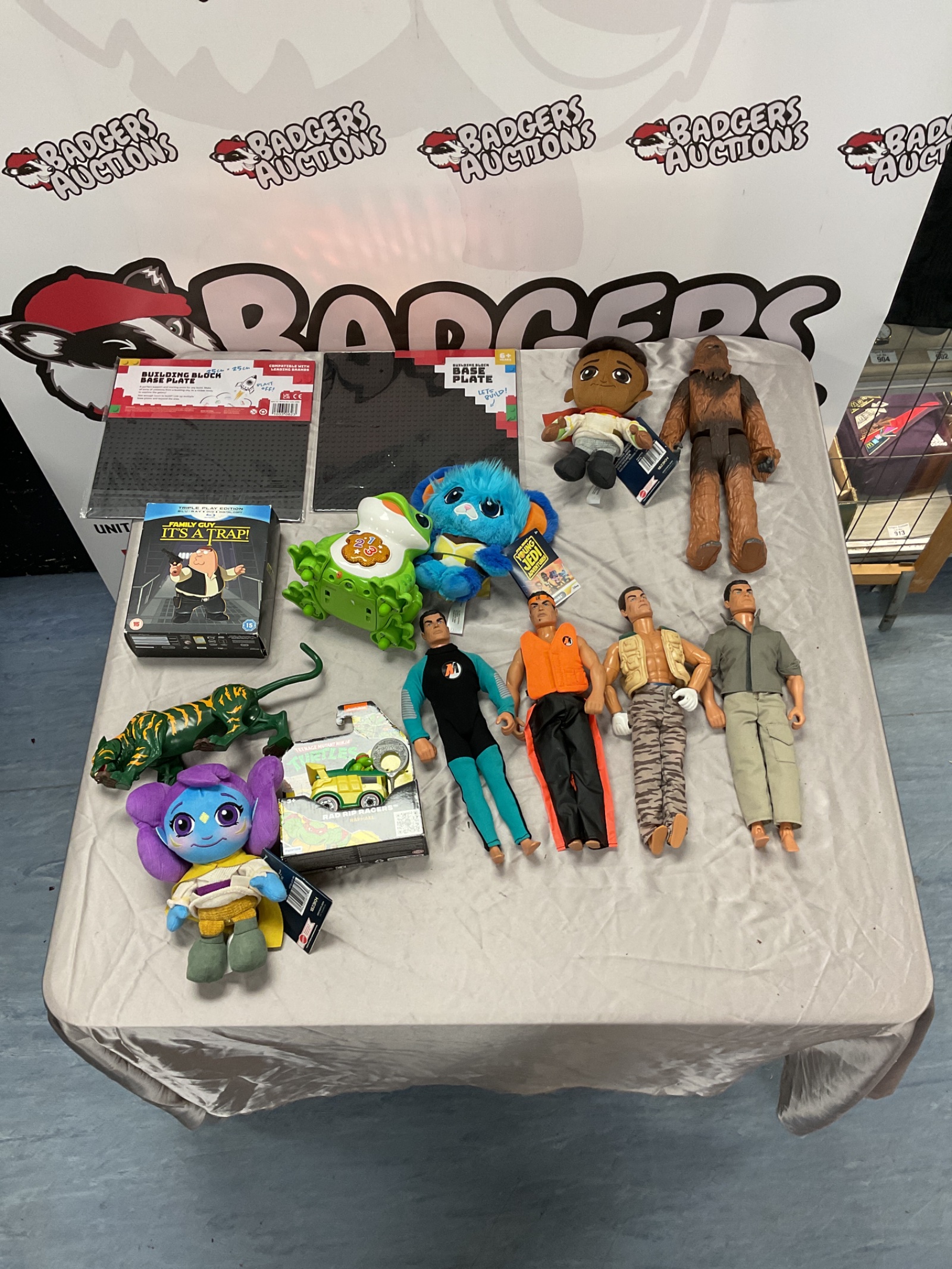 456 Mixed box of toys incl. Action Man action figures, Chewbacca figure, two building block base plates, Family Guy blu ray box set, Teenage Mutant Ninja Turtles Rad Rip Racers Raphael