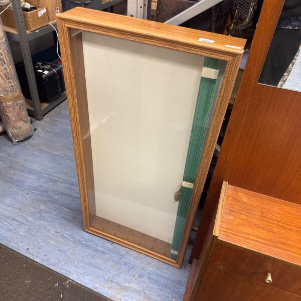 Vintage model car display cabinet with glass front and shelving.
