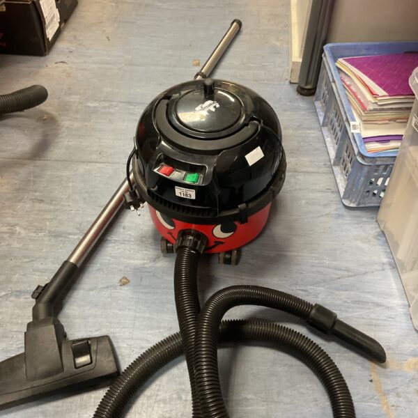 Red Numatic Henry vacuum cleaner with hose attached.