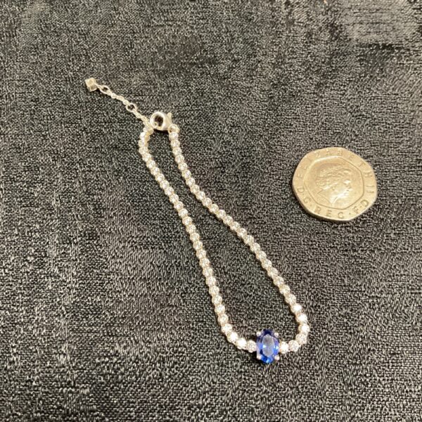 Pandora silver bracelet with blue stone detail.
