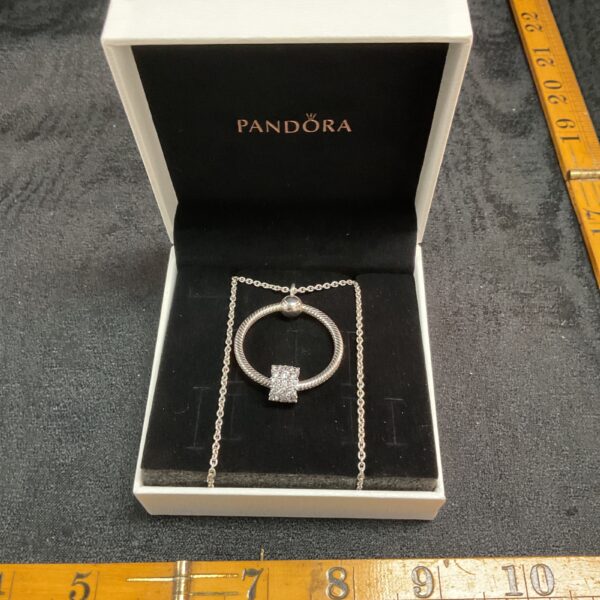 Pandora sterling silver necklace with ring and charm pendant.