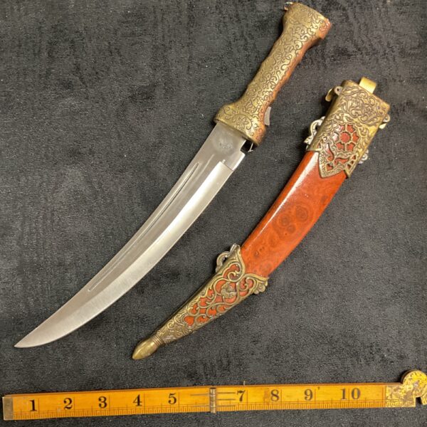 Antique Persian dagger with detailed brass handle and curved blade.