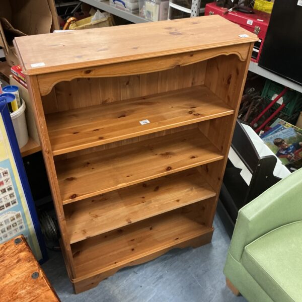 Solid pine four-shelf bookcase for home storage.