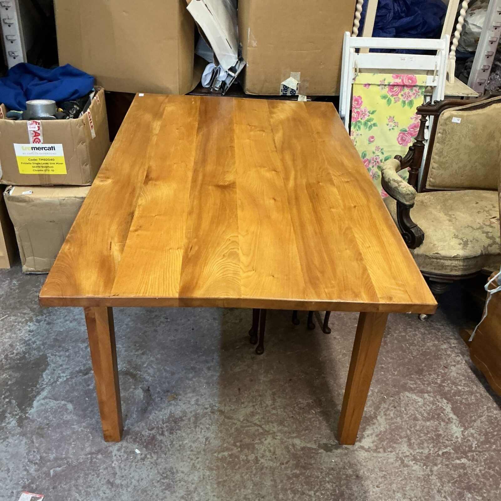 Rustic pine kitchen table with visible wood grain and signs of wear.