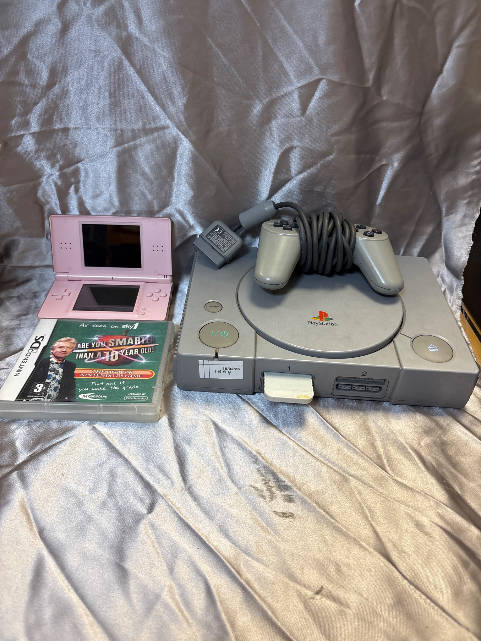 191 Sony PlayStation one console with controller and Nintendo DS lite console with game