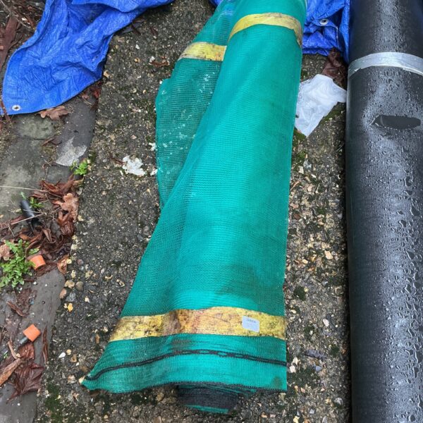 Green roll of pond protection netting for garden ponds.