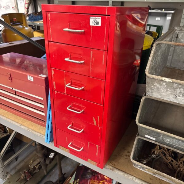 Red metal tool cabinet with drawers, vintage workshop storage solution.