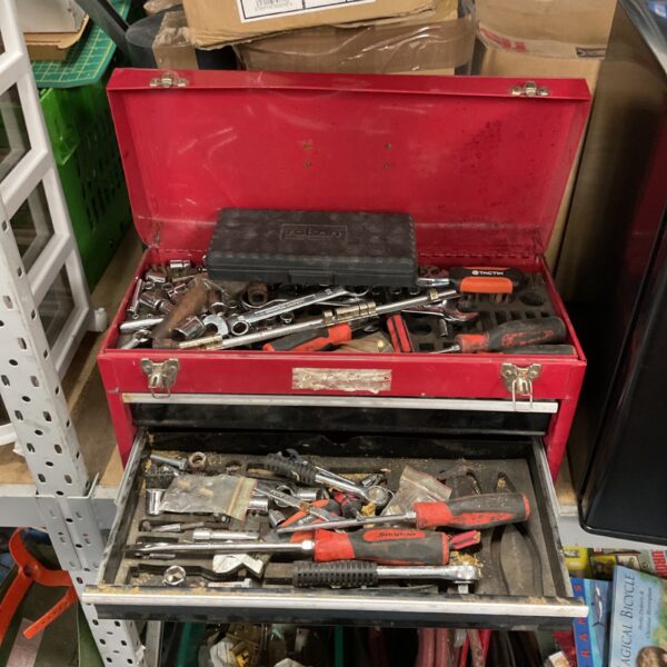 Red steel tool box filled with various workshop tools.