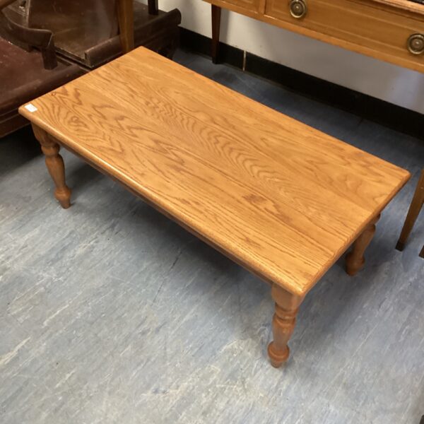 Rustic pine coffee table with turned legs in a home setting.