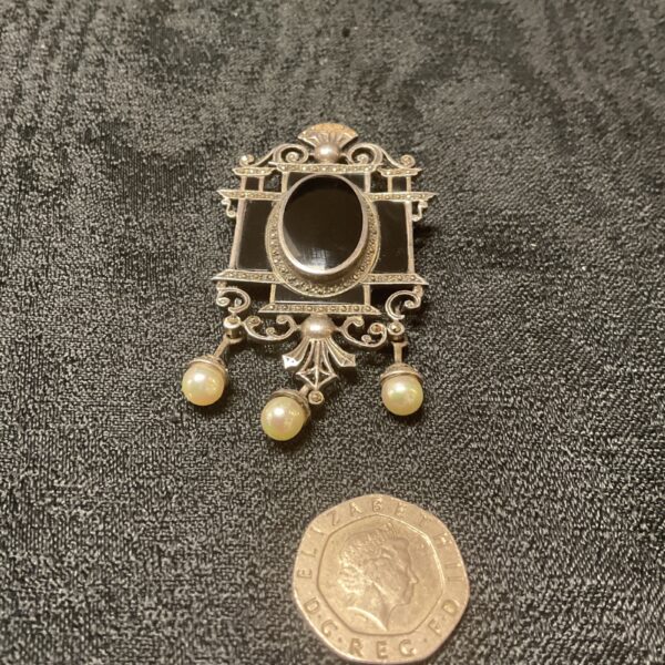 Antique silver marcasite brooch with onyx and pearl detail.