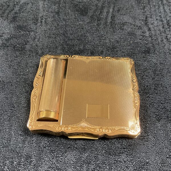 Vintage gold Stratton compact open, showing mirror and powder well.
