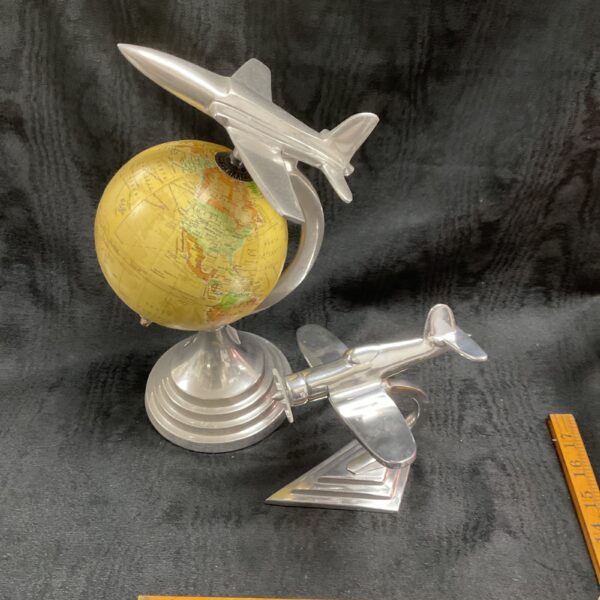 Vintage alloy model aircraft ornament on globe base.