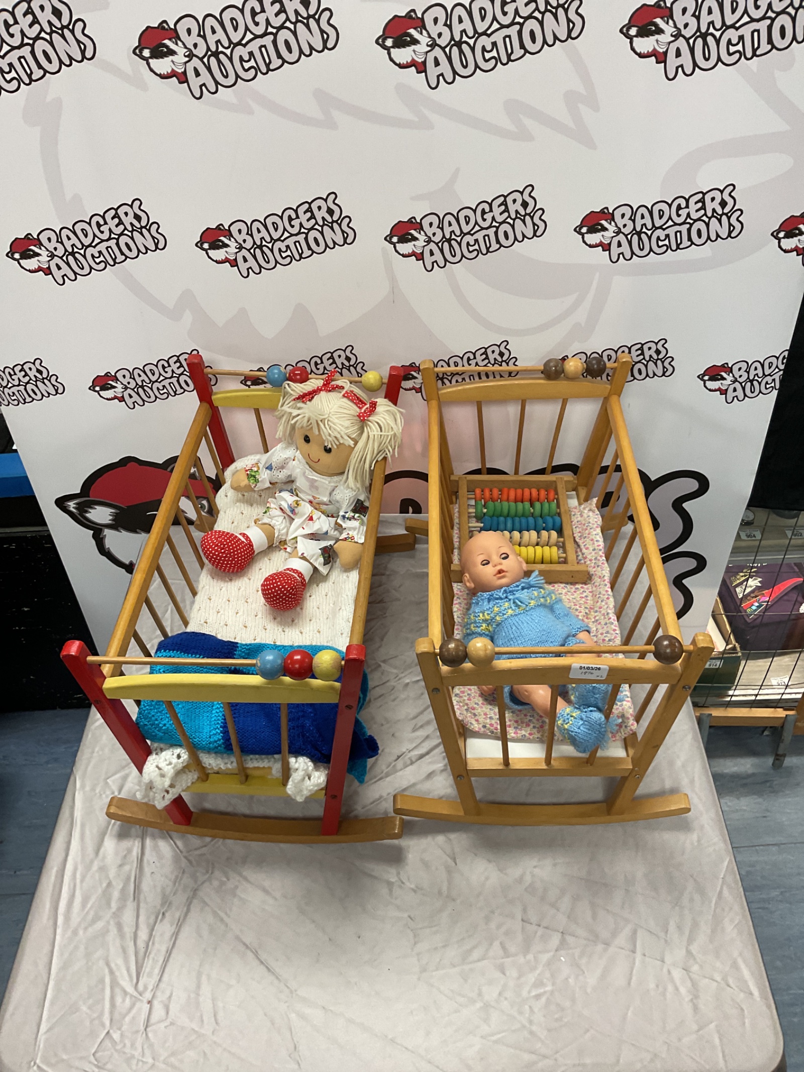 374 Two wooden baby doll cribs with dolls and abacus toy