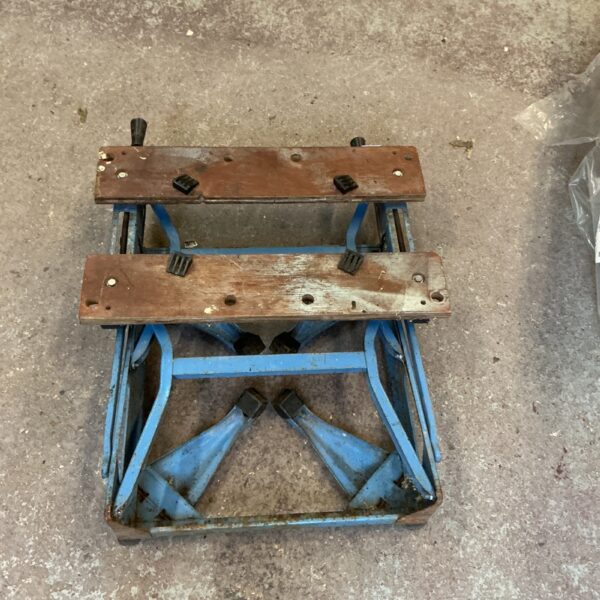 Vintage folding workbench with metal frame and wooden top.