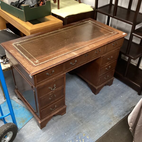 Vintage leather top desk with mahogany finish and drawers.
