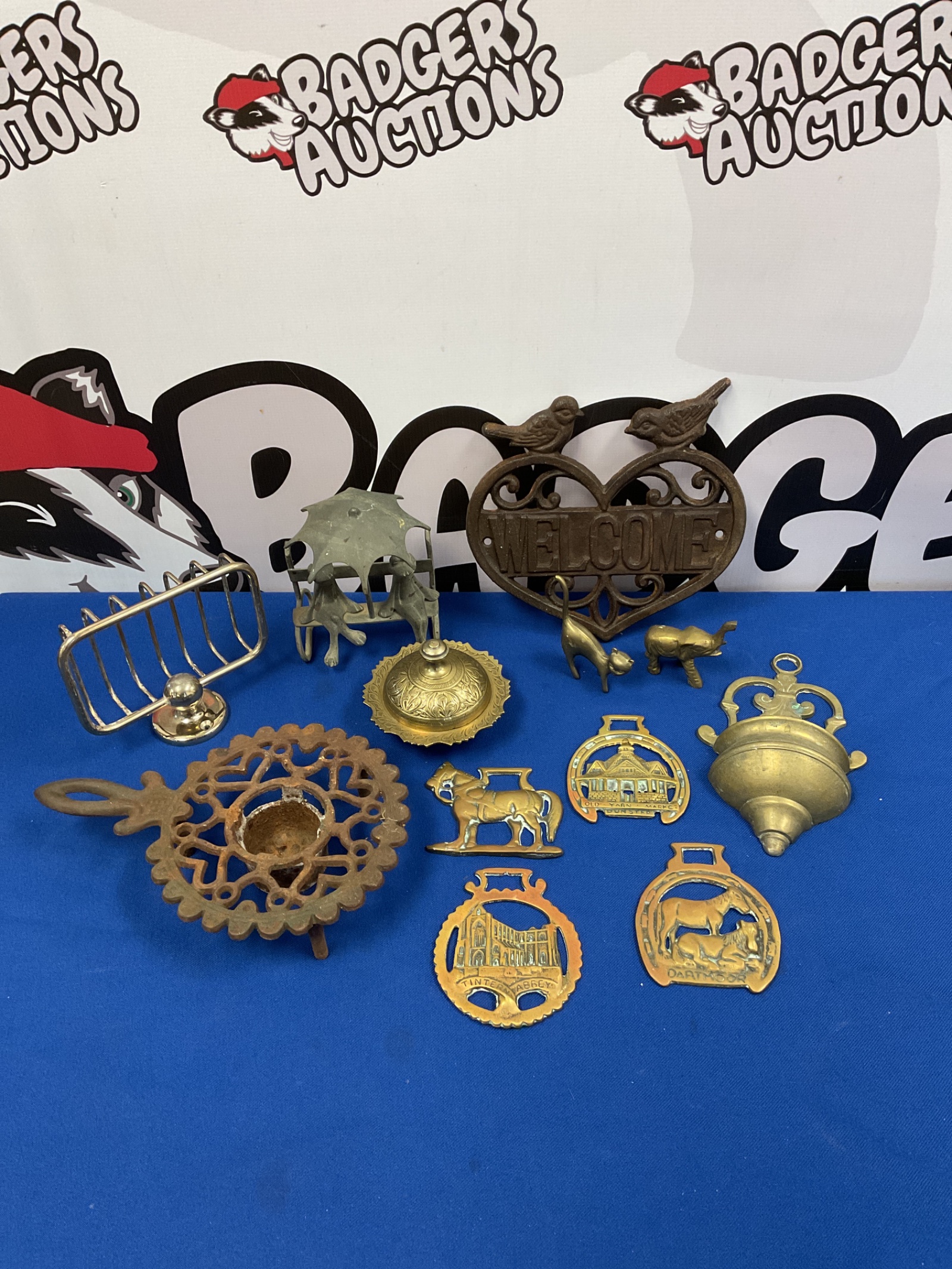 062 Selection of metalware inc cast iron trivet, welcome sign & brass salt pot & horse brasses