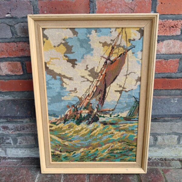 Vintage framed embroidery of a ship in rough seas.