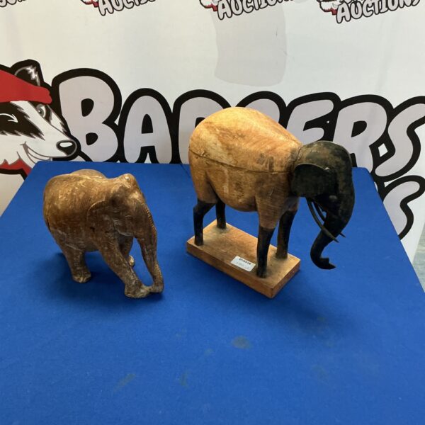 Pair of intricately carved wooden elephants, collectible animal figurines.
