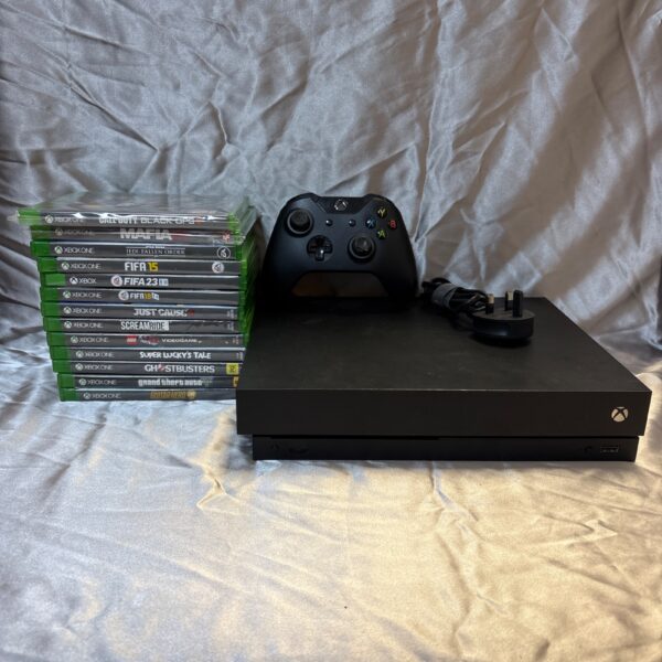 Used Xbox One X console with controller and power cable for gaming.