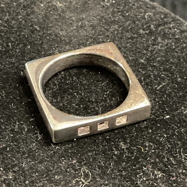 Close-up of a 925 silver square ring, minimalist design.